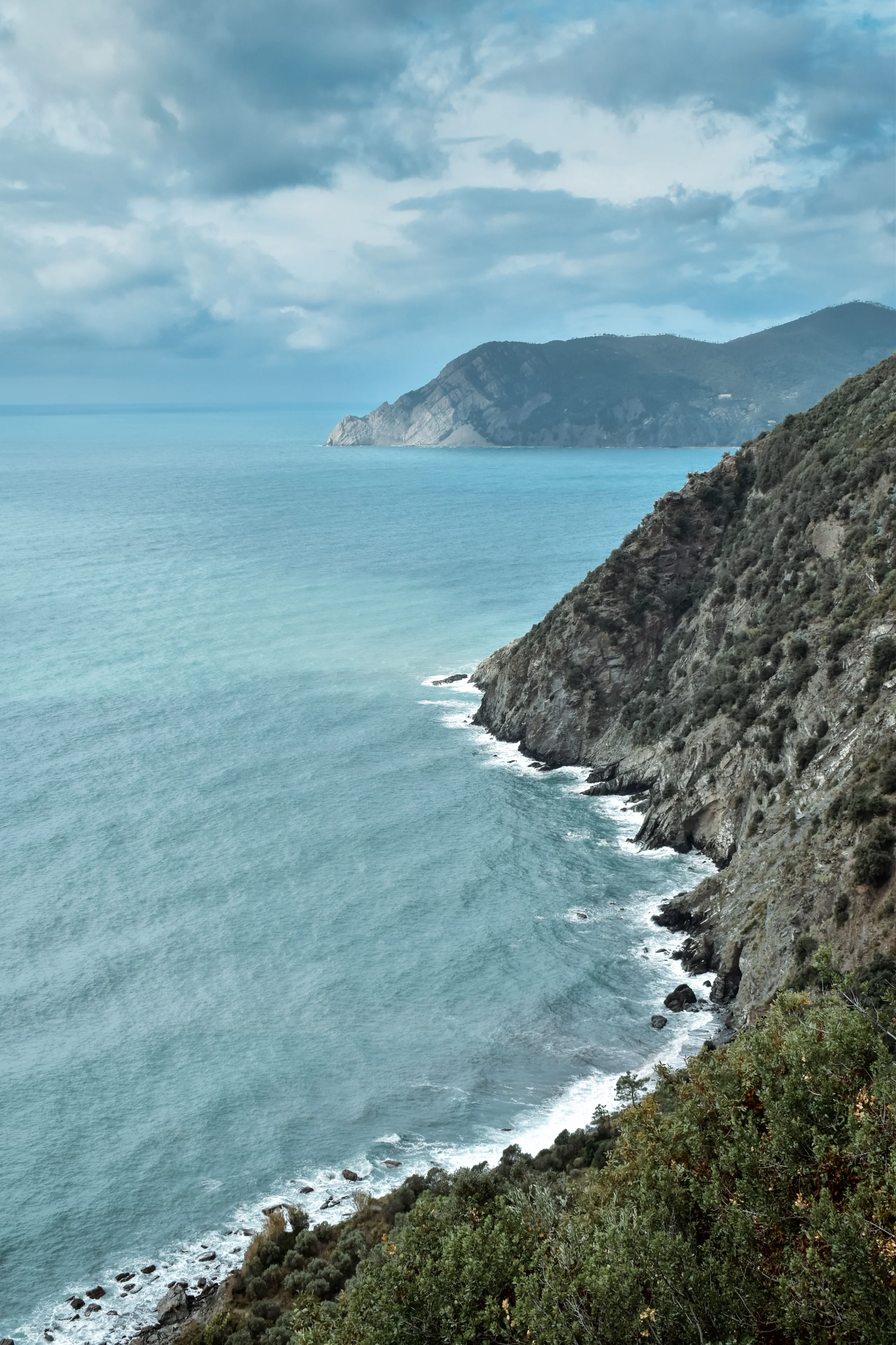 Explore the breathtaking Ligurian coastline with dramatic cliffs and azure waters under a cloudy sky jigsaw puzzle
