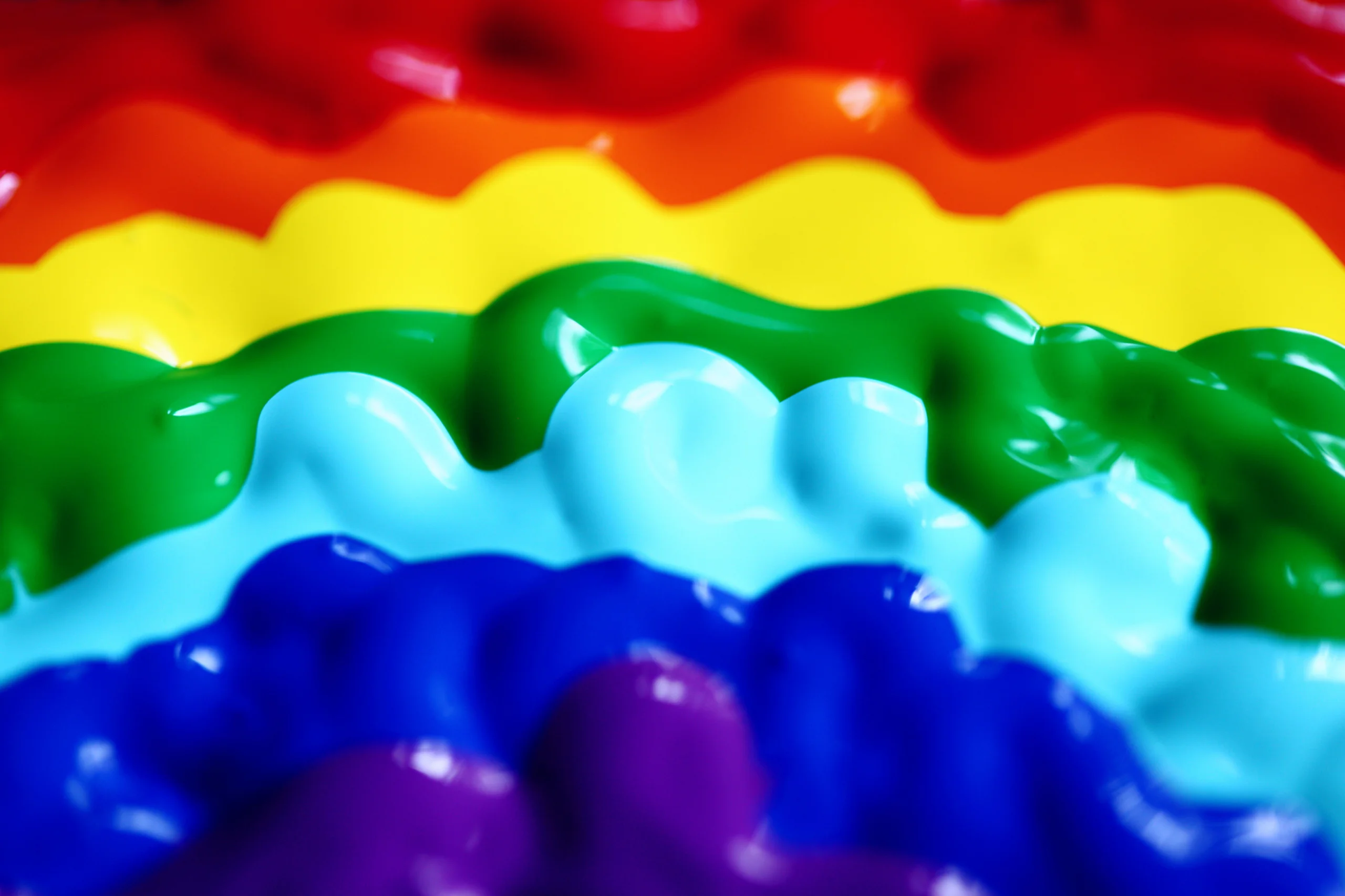A close-up of colorful rainbow paint waves displaying vibrant hues in a creative pattern. jigsaw puzzle