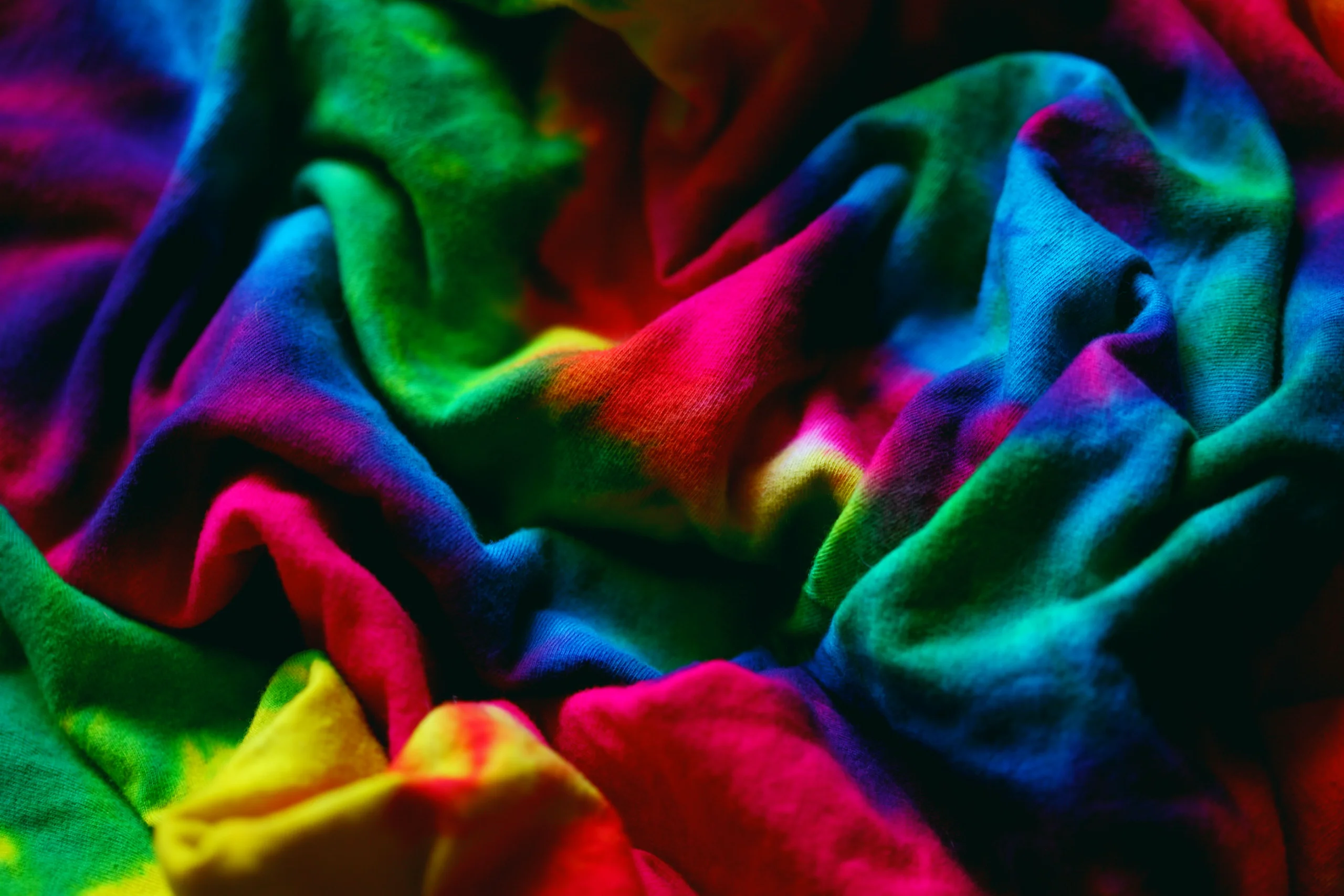 Colorful close-up of crumpled tie-dye fabric showcasing vibrant hues and dynamic patterns. jigsaw puzzle